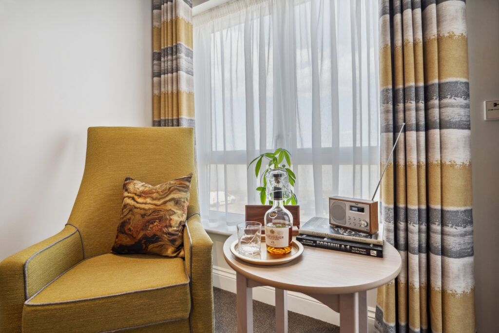 Ocean Heights Care Home arm chair and table with seaside view